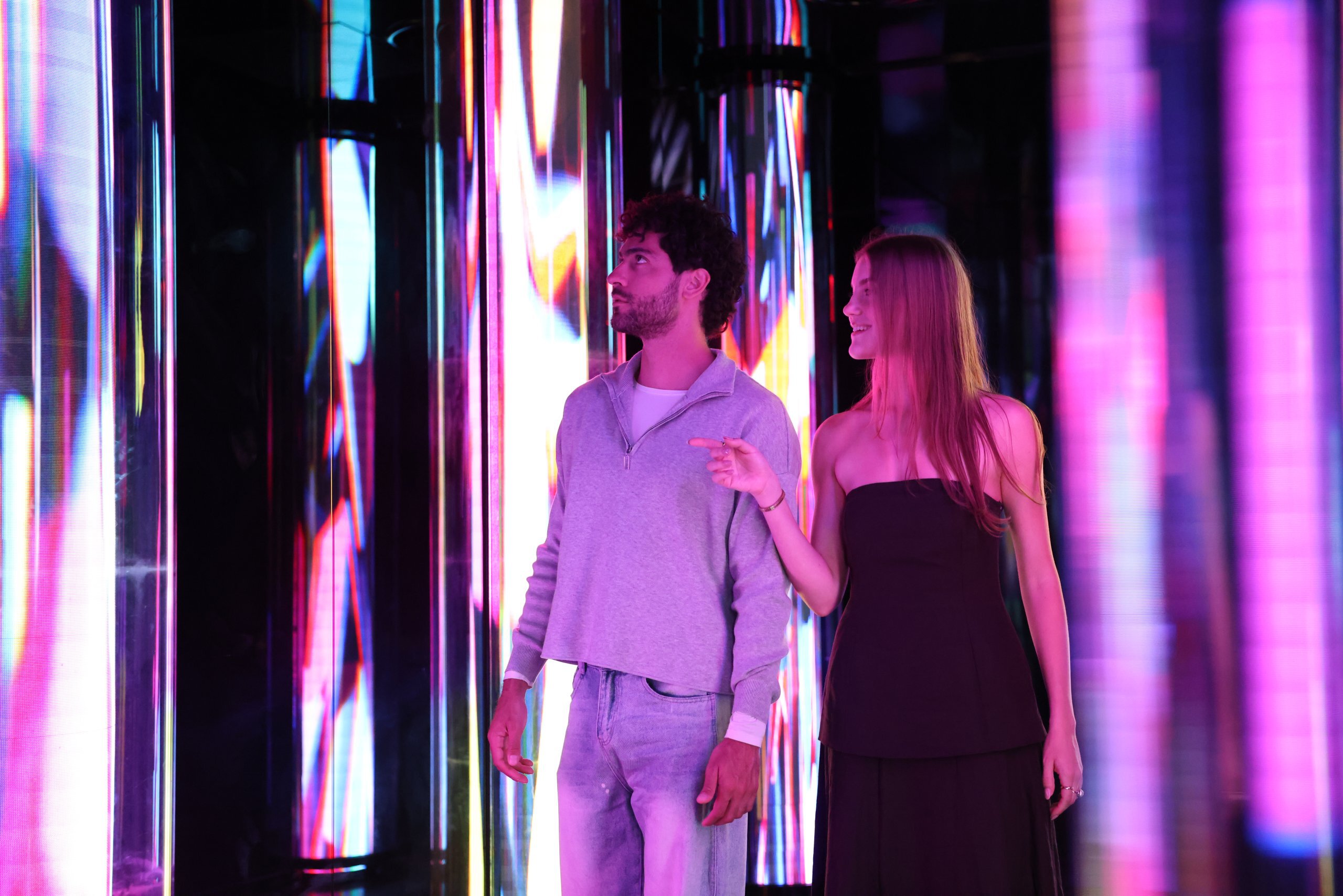 Guests experiencing immersive indoor installations at Edge NYC with reflective lighting effects.