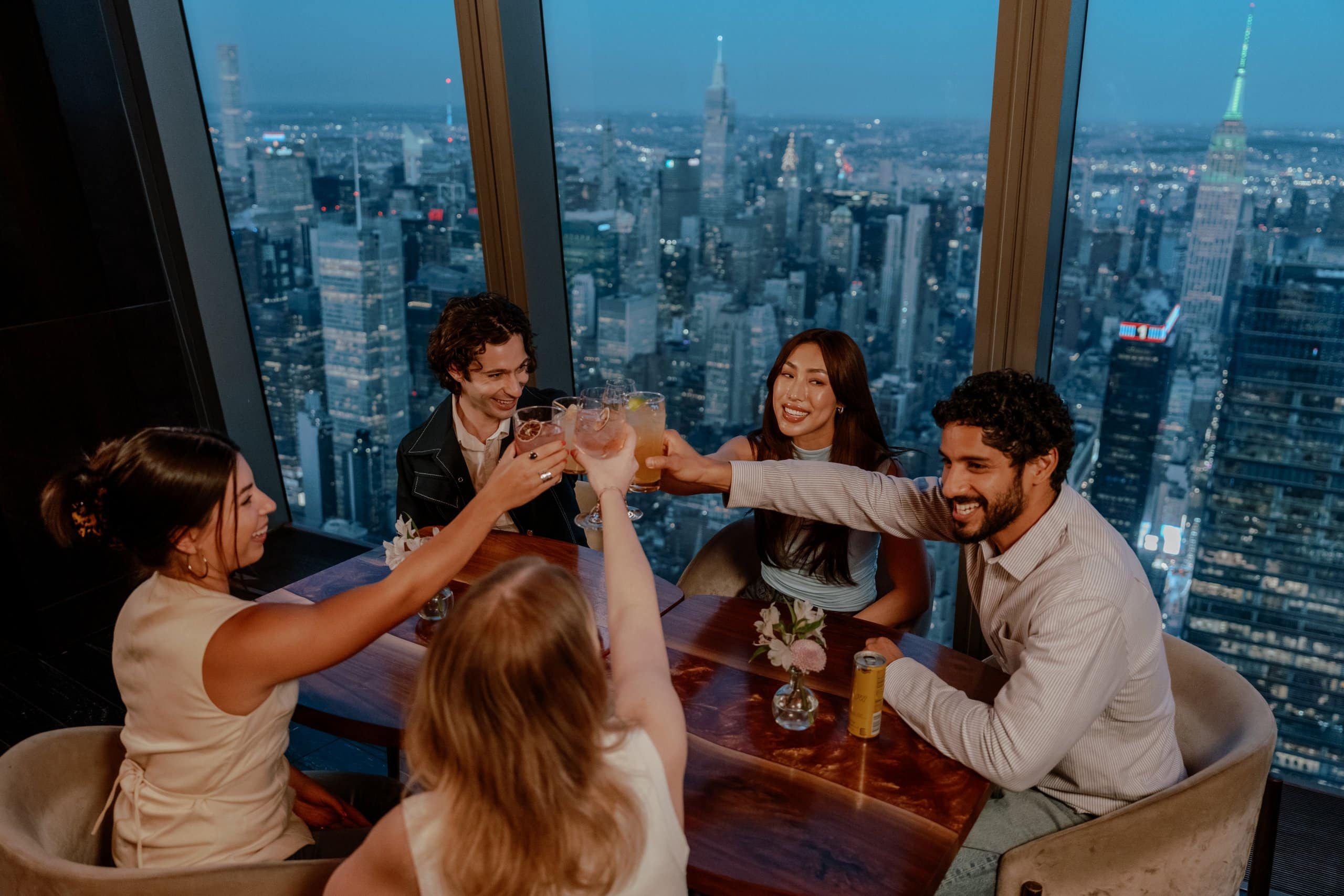 Guests enjoying premium dining and cocktails at Edge NYC with skyline views