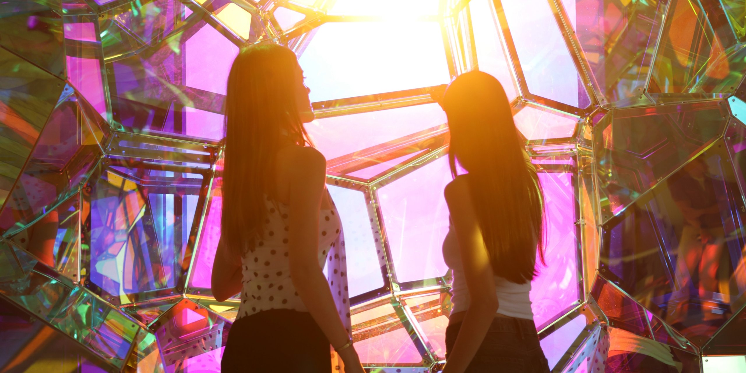 Visitors exploring immersive indoor installations at Edge NYC with outdoor skyline views of Manhattan